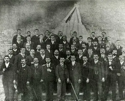 Fotografia antiga dels cantaires de la Societat, un grup d'homes amb vestit i barret